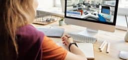 Teenage girl seated at desk at home in front of a computer displaying a Labster simulation